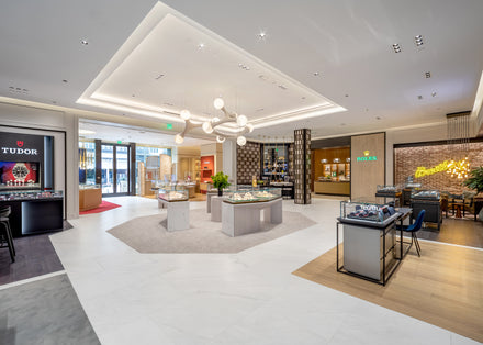 Modern jewelry and watch store interior with display cases, designer brands, and bright lighting.