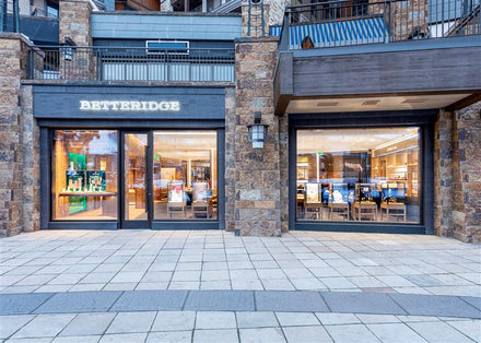 Exterior view of a Betteridge jewelry store with large glass windows and stone walls.