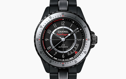 Chanel watch with black strap and detailed face on a white background