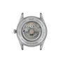 Stainless steel watch case back showing mechanical movement with golden gears and Tissot branding.