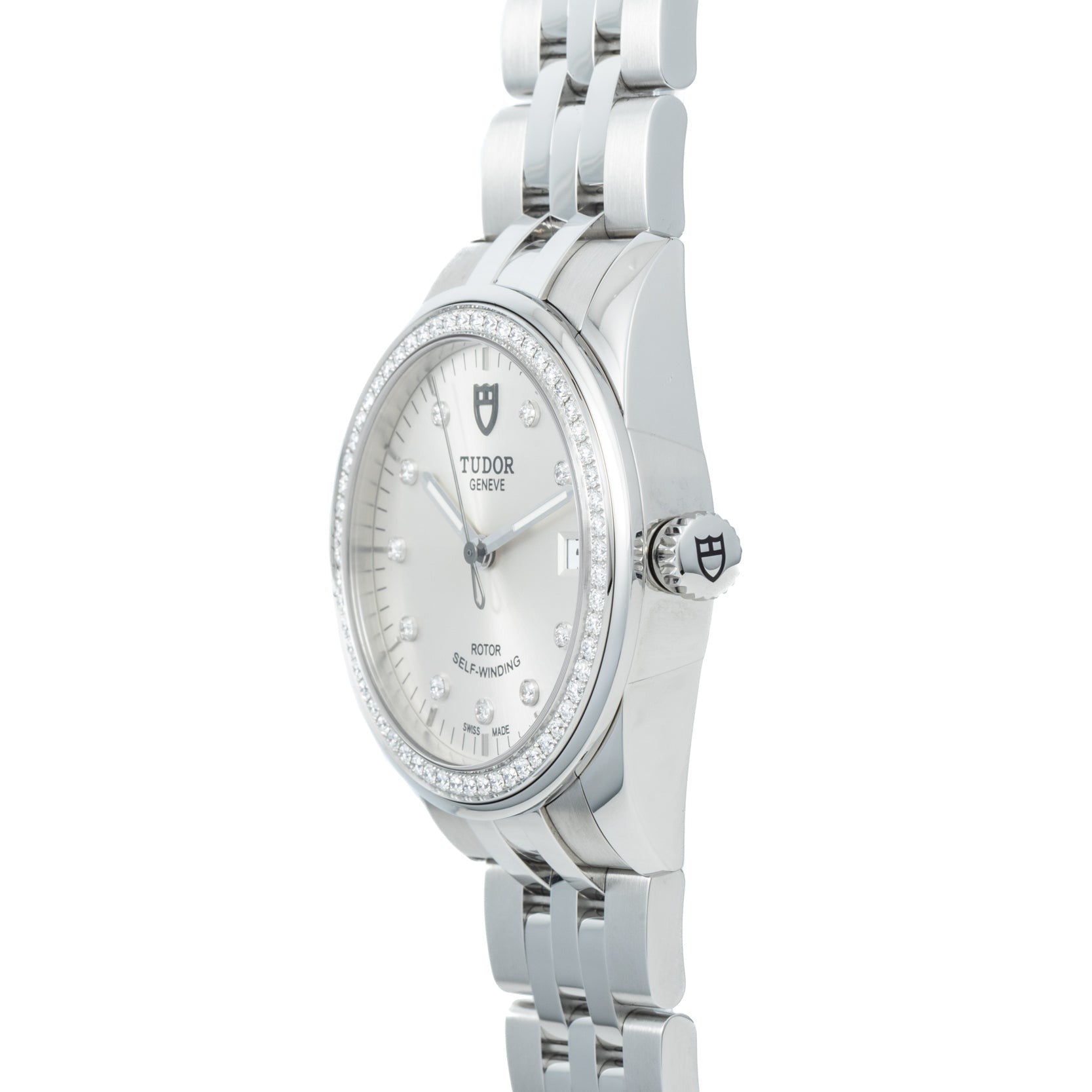 A TUDOR Glamour Date wristwatch with a diamond bezel and metal bracelet, displayed at an angle.