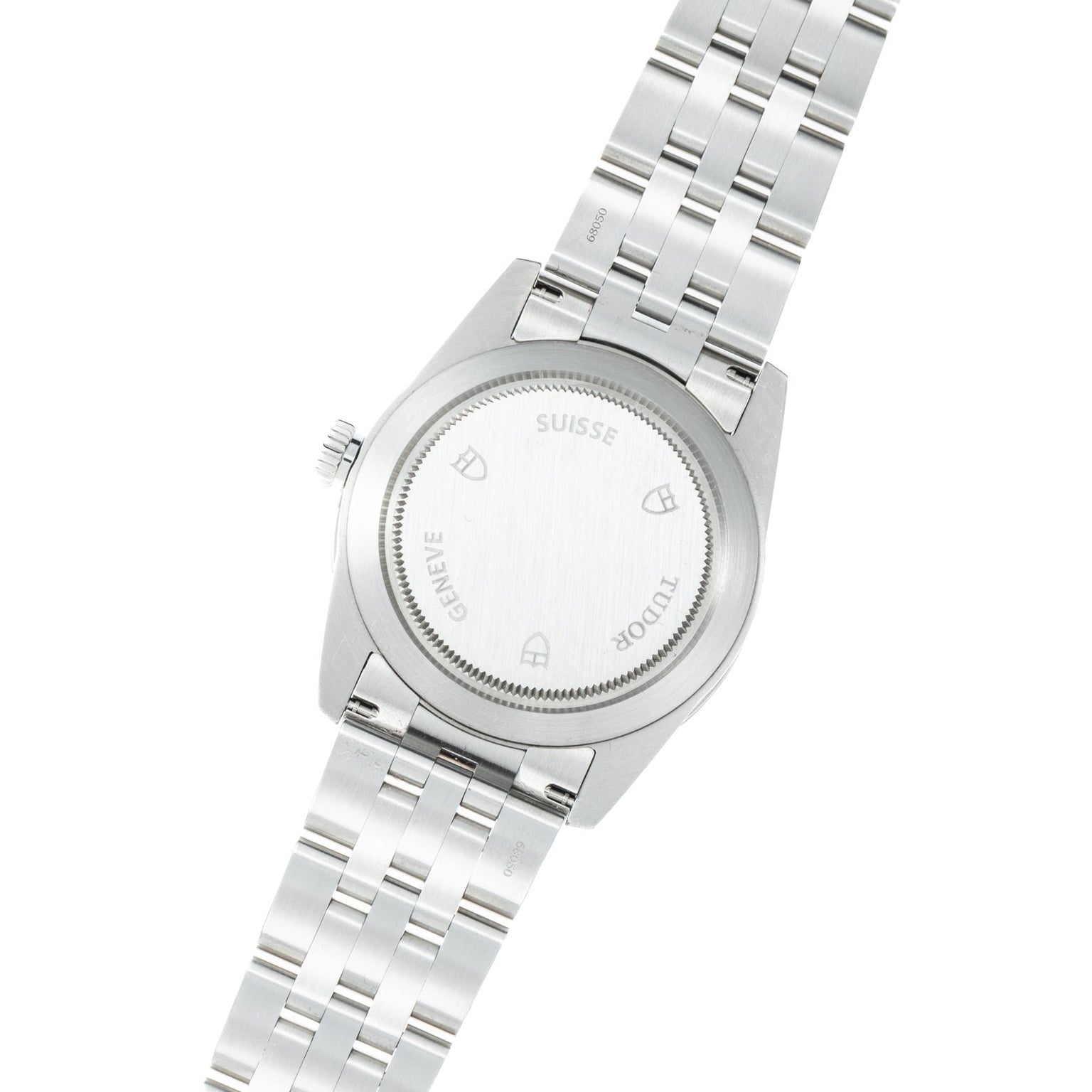 The back of a TUDOR Glamour Date wristwatch featuring stainless steel, a closed case, and a metal bracelet.