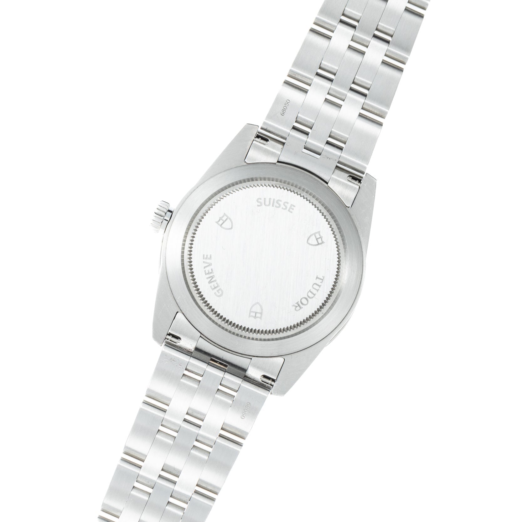The back of a TUDOR Glamour Date wristwatch featuring stainless steel, a closed case, and a metal bracelet.