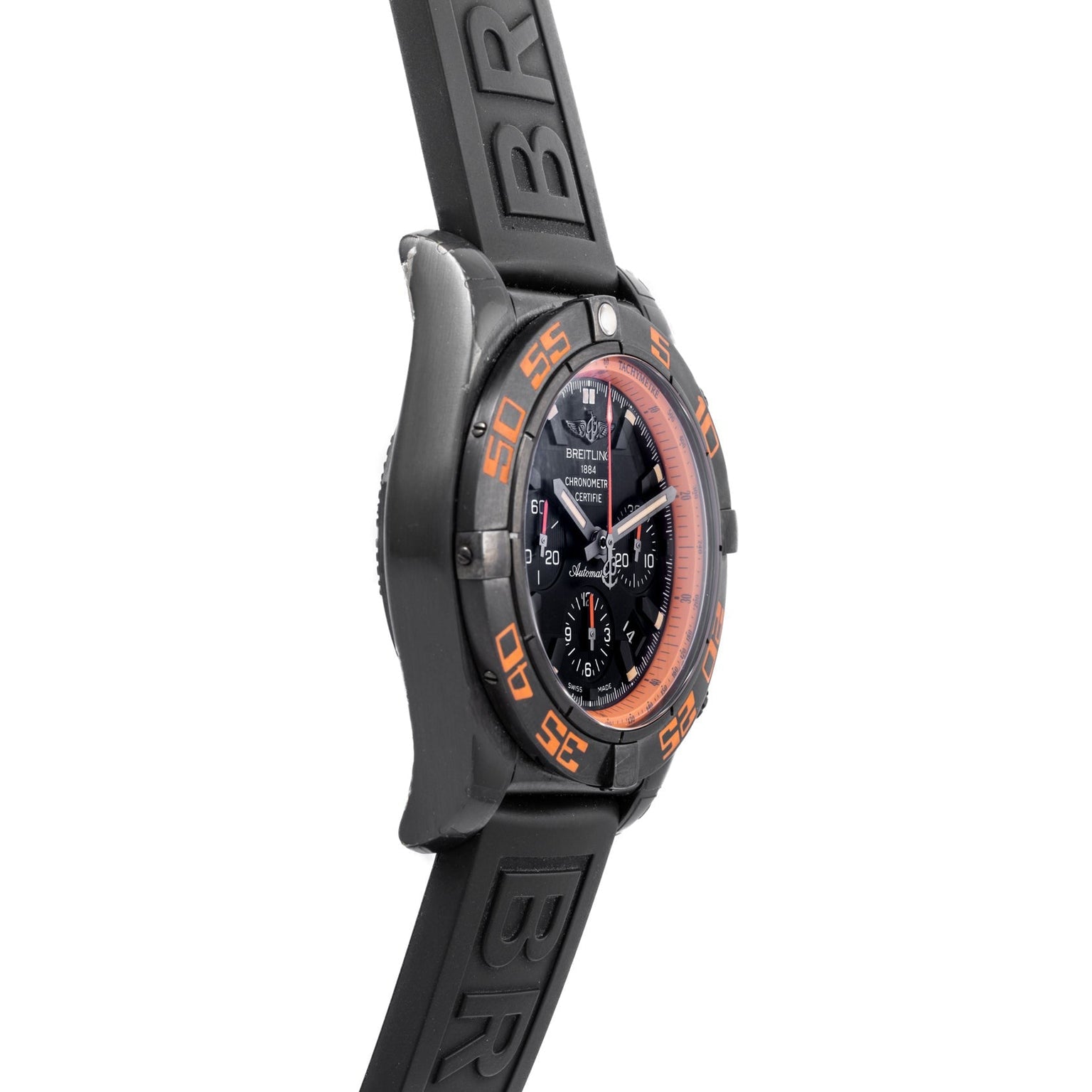 Side view of a Breitling Chronomat Raven wristwatch featuring a black case, orange accent bezel, and black rubber strap.
