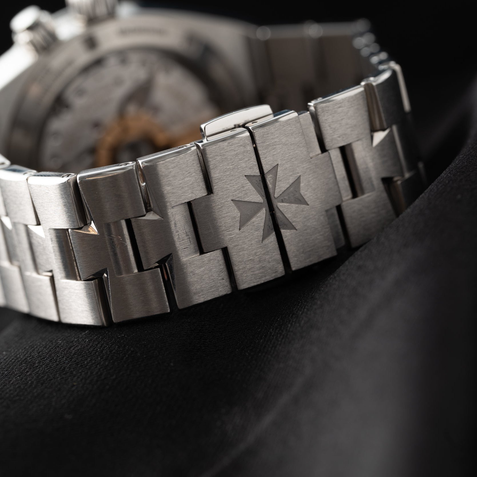 Close-up of the Vacheron Constantin Overseas Dual-Time stainless steel bracelet featuring a Maltese cross engraved on the clasp.