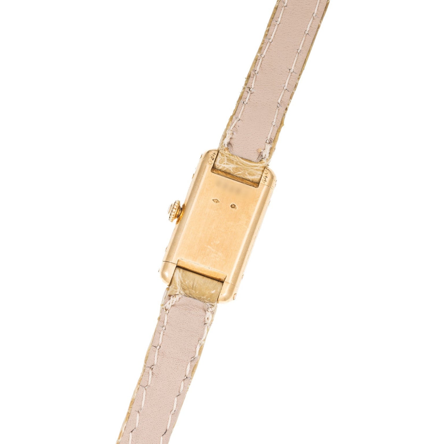 The Cartier Tank is a gold rectangular wristwatch with a beige leather strap, shown from the back displaying its case and detailed stitching.