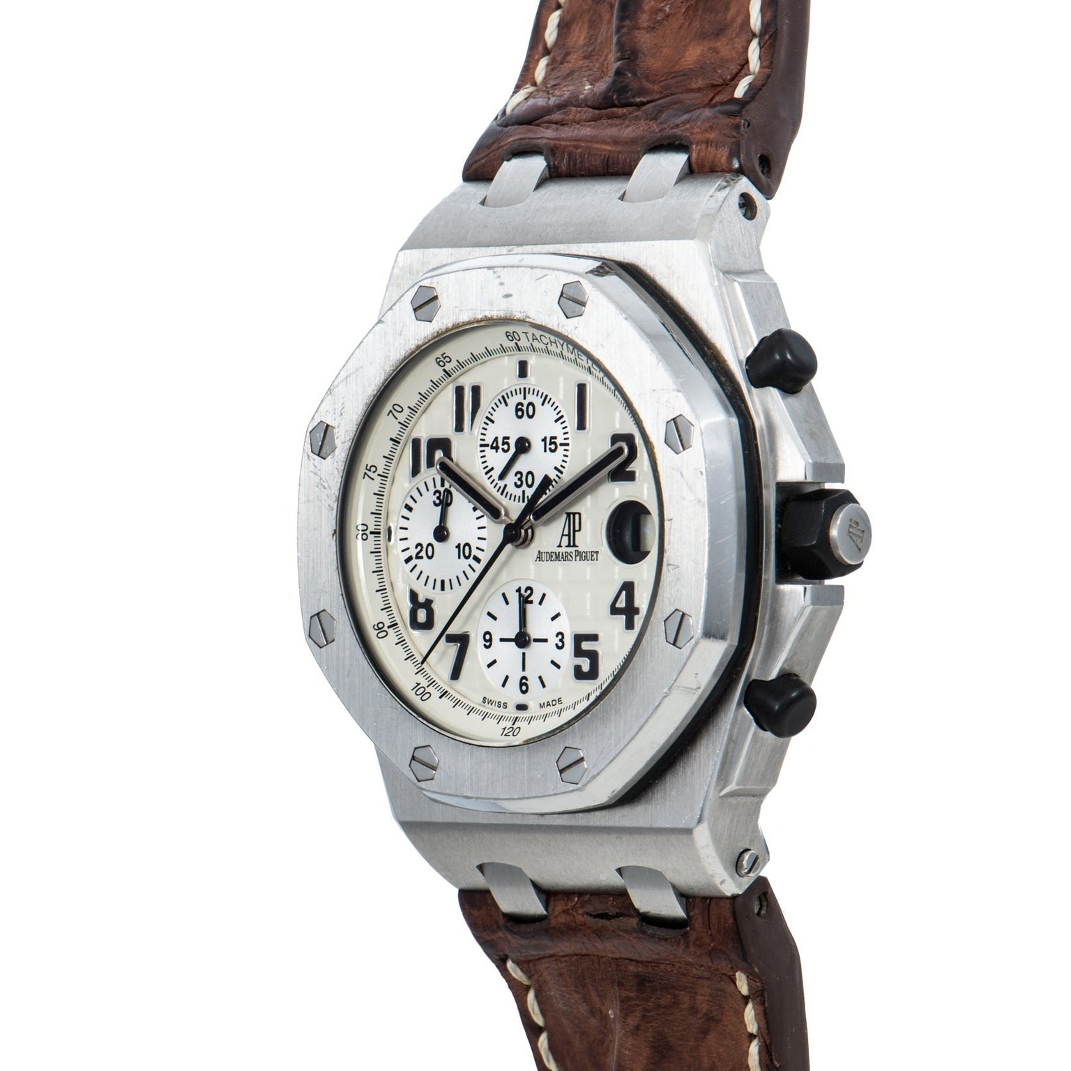 The Audemars Piguet Royal Oak Offshore Safari is a silver chronograph wristwatch with a white dial, black numerals, and a brown leather strap.