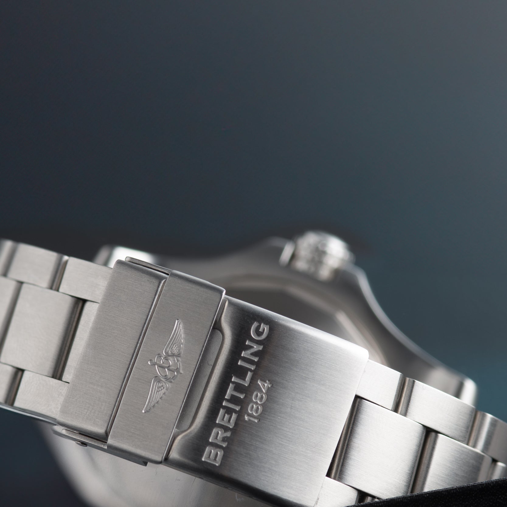 Close-up of a silver Breitling Avenger II Seawolf watch clasp, engraved with the logo and BREITLING 1884 on a metal band.