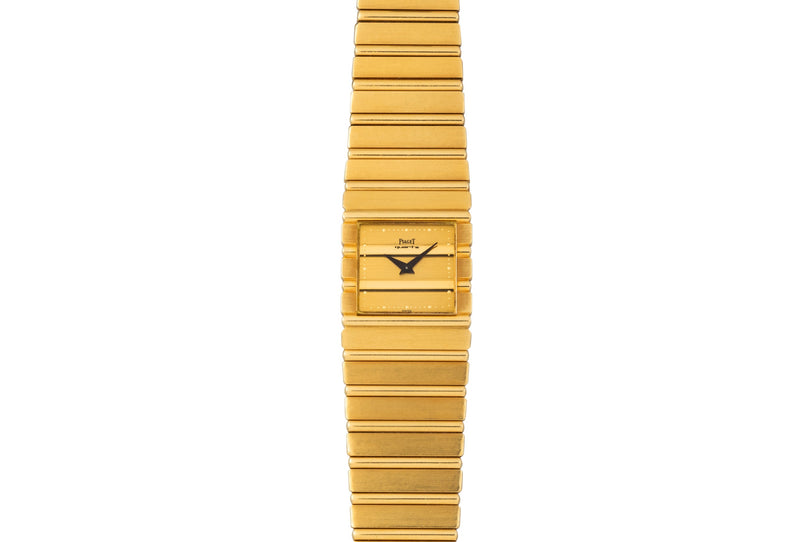 The Piaget Polo is a gold rectangular wristwatch featuring a matching gold link bracelet and simple black hour and minute hands.