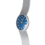 The Patek Philippe Calatrava Backwind is a silver wristwatch with a blue face and silver hour markers, shown against a white background.