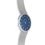 The Patek Philippe Calatrava Backwind is a silver wristwatch with a textured band and a blue, patterned face featuring silver hour markers.