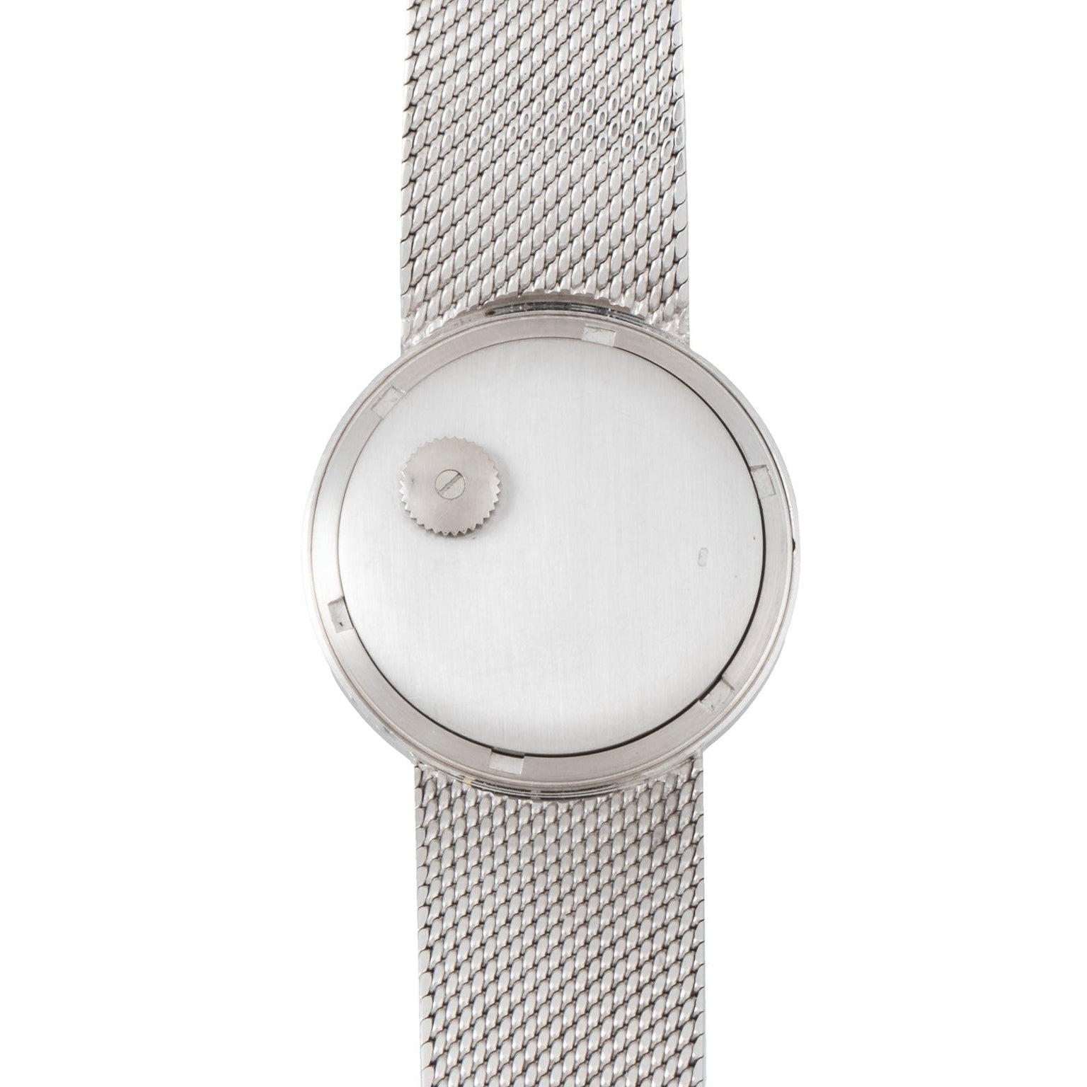 The Patek Philippe Calatrava Backwind is a minimalist silver wristwatch featuring a mesh band and a single off-center crown on its blank dial.