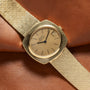 Yellow Gold Hobnail Dress Watch by Piaget featuring a minimal dial and date window on a brown leather strap.