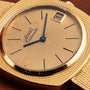 Piaget Yellow Gold Hobnail Dress Watch featuring blue hands, black hour markers, and a date window displaying 1 on the dial.
