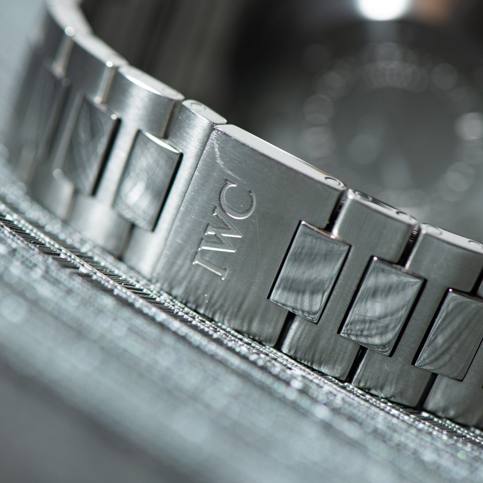 Close-up of the IWC Schaffhausen Aquatimer GST 2000s silver metal bracelet, featuring the engraved IWC logo on its clasp.