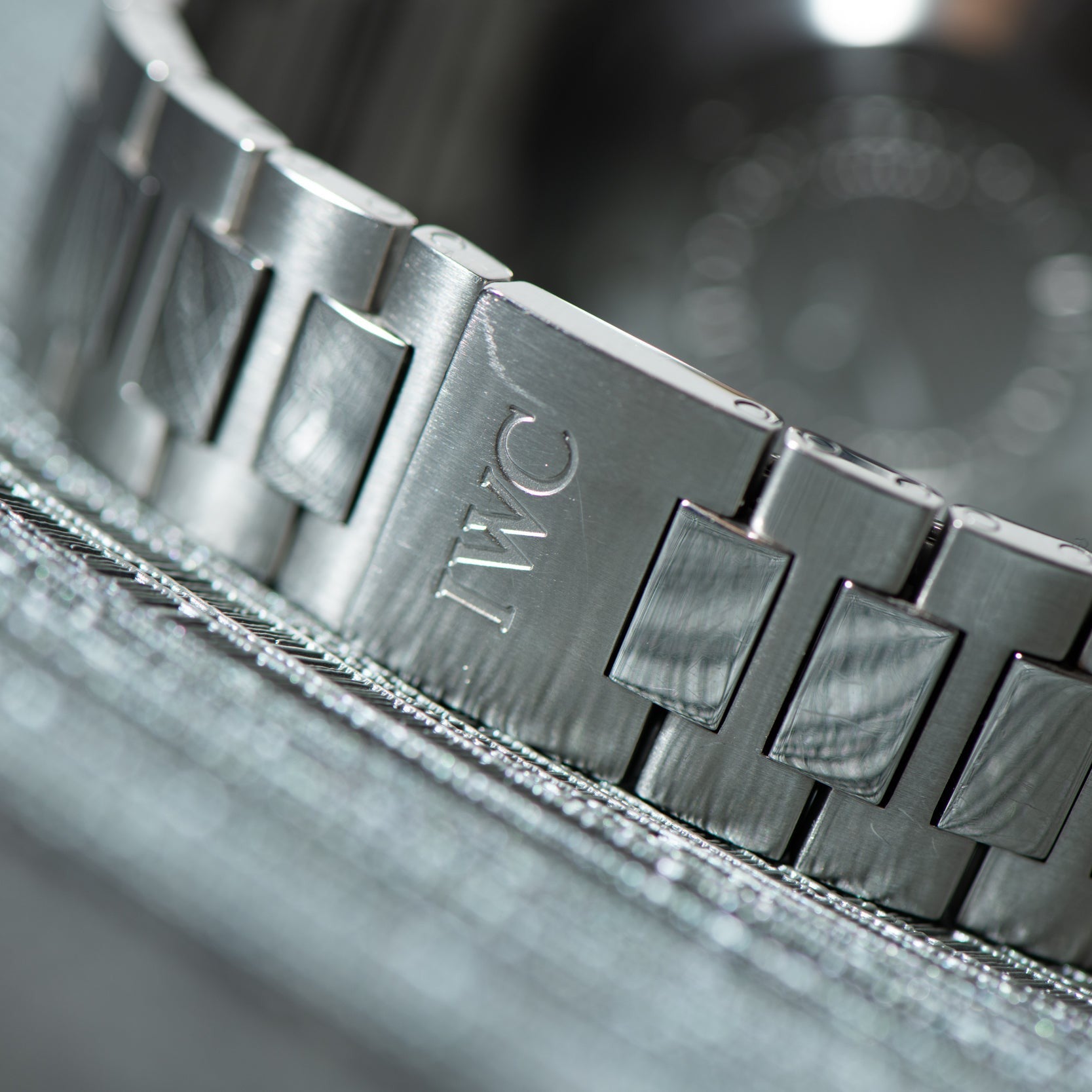 Close-up of the IWC Schaffhausen Aquatimer GST 2000s silver metal bracelet, featuring the engraved IWC logo on its clasp.