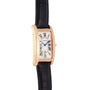 Cartier Tank Americaine gold wristwatch with a rectangular face, Roman numerals, and a black leather strap.