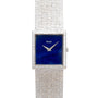 A Piaget White Gold Lapis Lazuli Dress Watch with a square blue face and textured metal band is displayed on a white background.