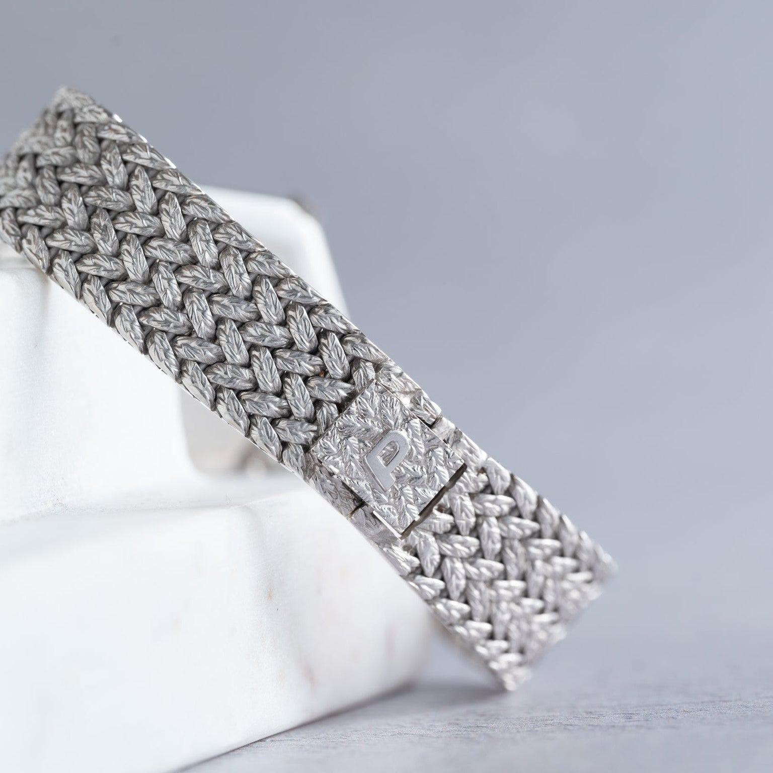 A close-up of the Piaget Hexagonal Diamond Dress Watch featuring a metal clasp engraved with the letter P.