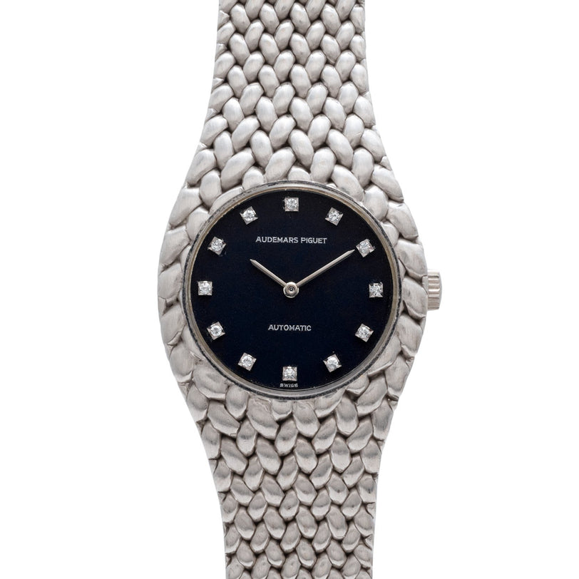 An Audemars Piguet Cobra watch in silver with a black face and diamond hour markers.