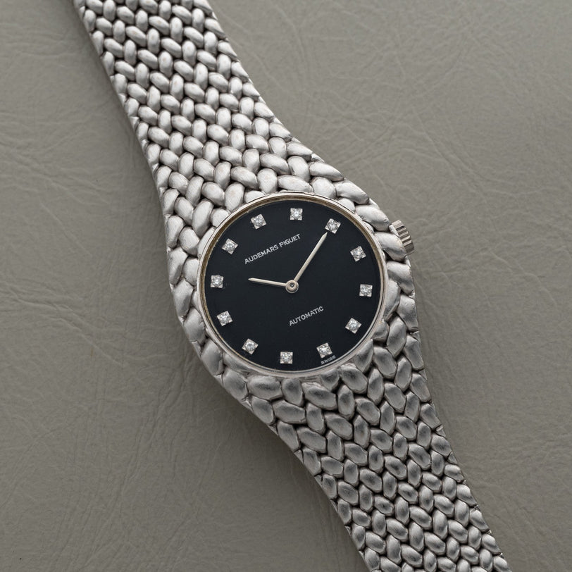The Audemars Piguet Cobra is a silver watch featuring a black dial, diamond hour markers, and a textured band.