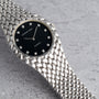 The Audemars Piguet Cobra is a luxury silver watch featuring a black dial, diamond hour markers, and a textured band.