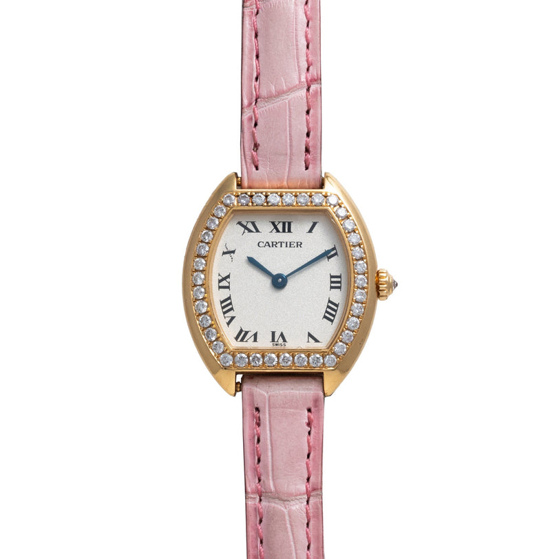 Cartier Tortue watch with diamond bezel, Roman numerals, and pink leather strap displayed on a white background.