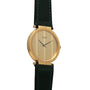 The Piaget Polo Large wristwatch features a round gold face, a gold dial, and a black leather strap with green stitching.