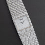 A Piaget Emperador Diamond wristwatch with a textured square dial and matching silver bracelet displayed on a black surface.