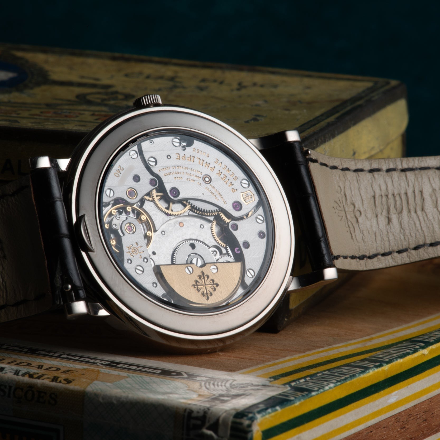 A close-up of the intricate inner mechanism of the Patek Philippe Perpetual Calendar Moonphase wristwatch displayed on a vintage book.