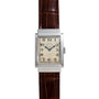 The Vacheron Constantin Rectangular Steel Dress Watch features a vintage look with a brown leather strap and a white dial with black numerals.