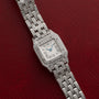 Cartier Panthère Diamond wristwatch with diamond accents displayed on a red textured background.