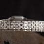 Close-up of the Cartier Panthère Diamond bracelet, featuring a silver geometric design adorned with small diamonds, set against a dark background.