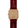 Back of a Cartier Santos Dumont wristwatch with a red leather strap and an 18K gold case, marked “Paris” and “Swiss Made.”.