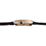 Side view of the Cartier Vendome gold wristwatch featuring a dark round crown and a thin black leather strap.