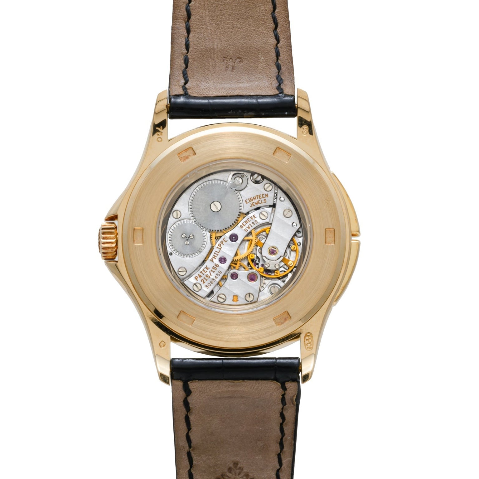 The back of the Patek Philippe Calatrava Travel Time showcases exposed mechanical gears and inner workings, complemented by a leather band.
