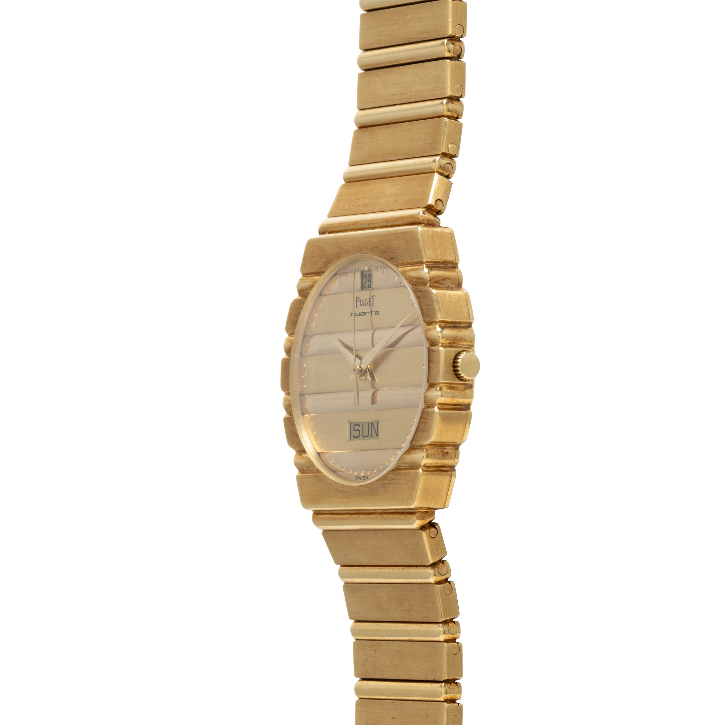 The Piaget Polo Calendar is a gold wristwatch with a rectangular face that shows the time and date, displayed against a white background.