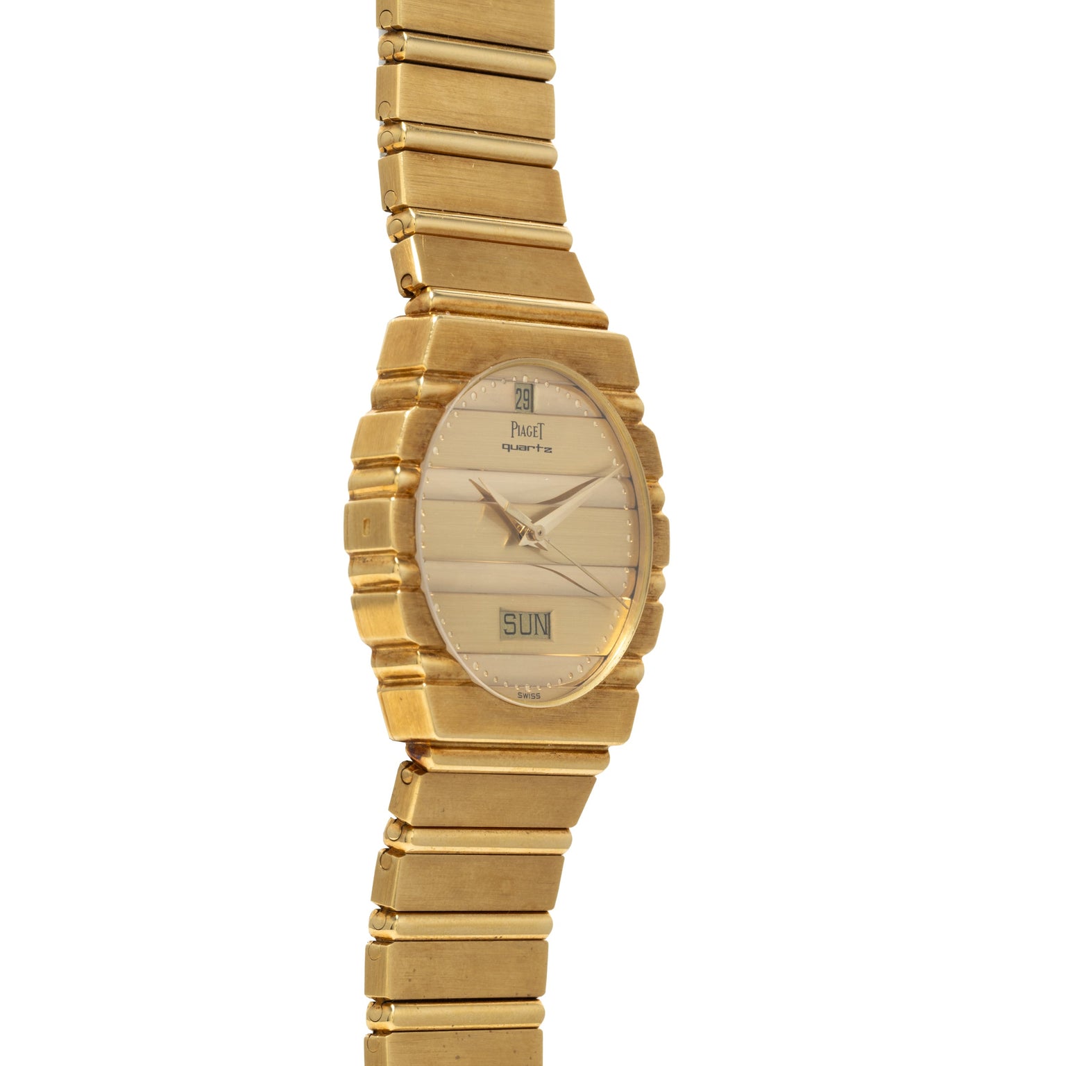 The Piaget Polo Calendar is a gold wristwatch featuring a rectangular face with day and date display on a matching gold metal band.