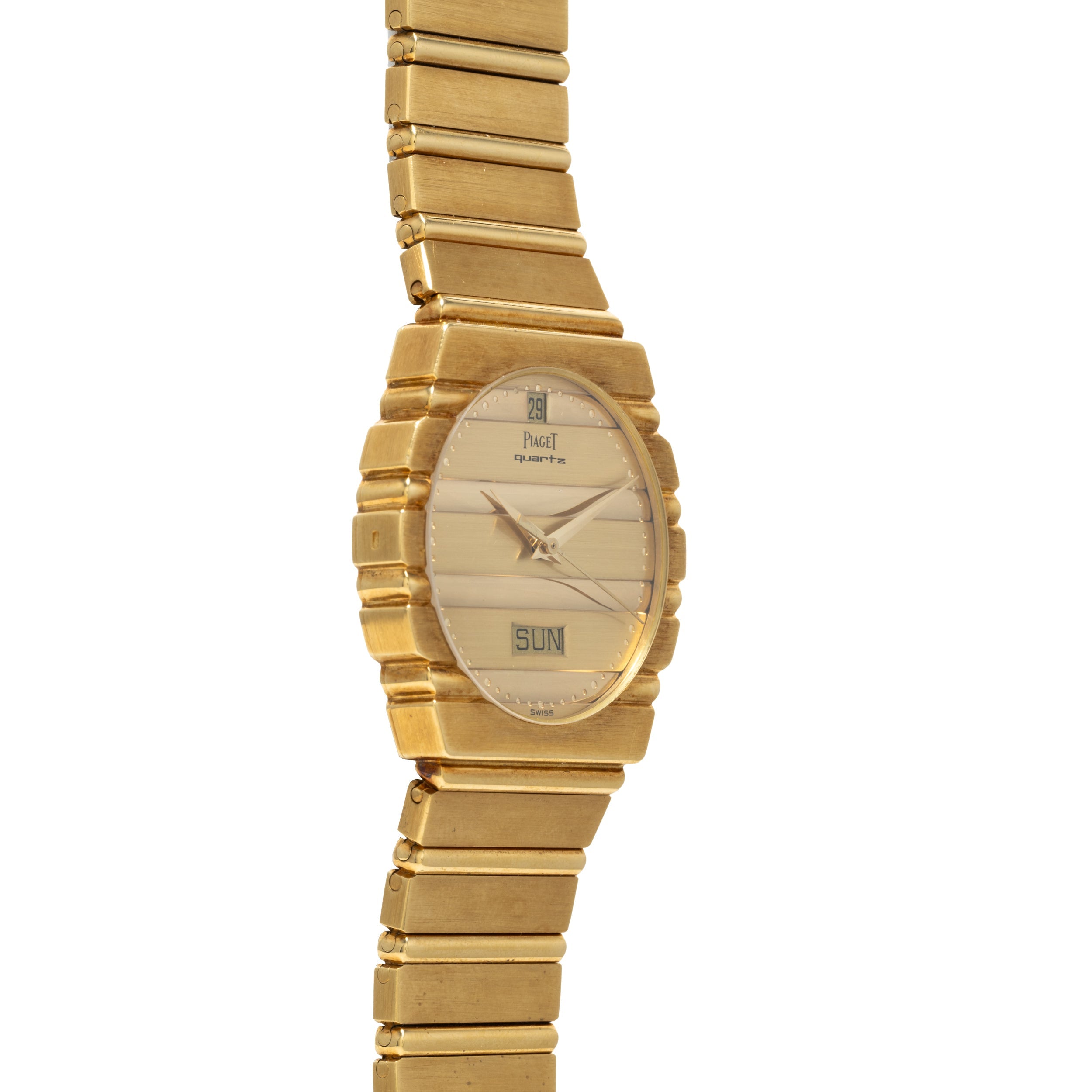 The Piaget Polo Calendar is a gold wristwatch featuring a rectangular face with day and date display on a matching gold metal band.