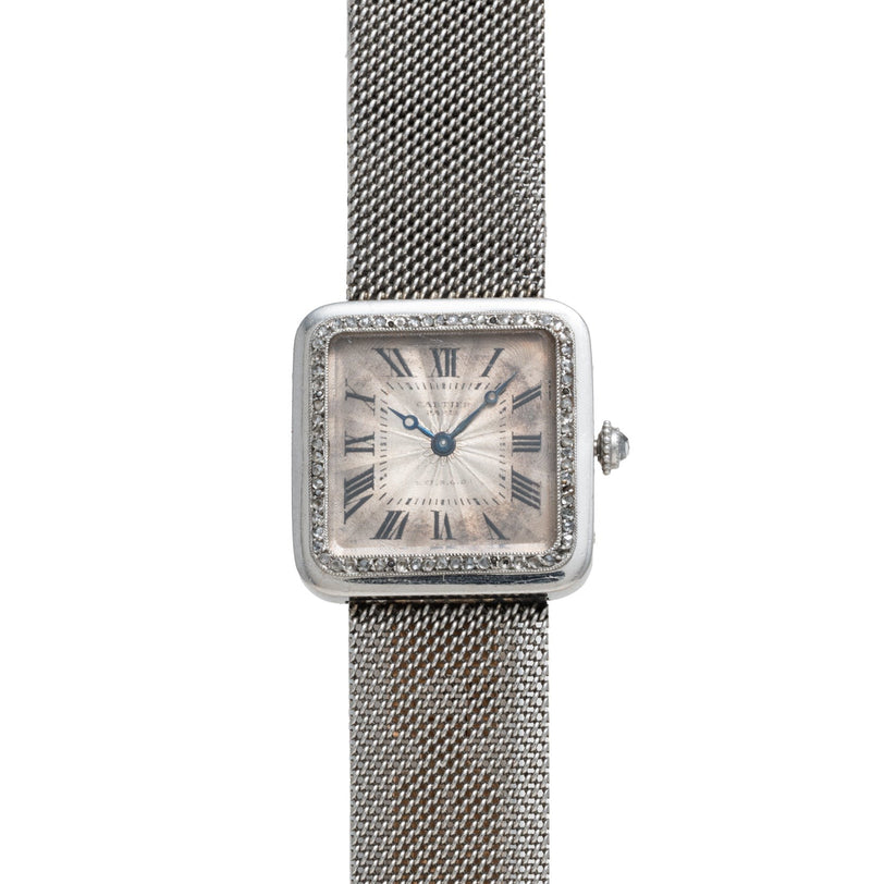 Cartier Santos Platinum: a square silver watch with Roman numerals, mesh band, two blue hands, and a textured bezel.