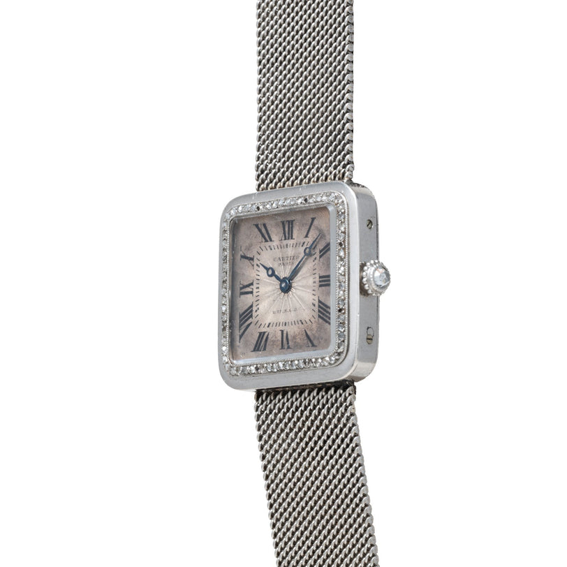 The Cartier Santos Platinum wristwatch features a square face, platinum mesh band, diamond accents, and Roman numerals on the dial.