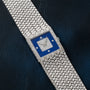 The Piaget Tradition Lapis Lazuli Diamond Dress Watch features a blue square face with diamond markers and a textured silver band.