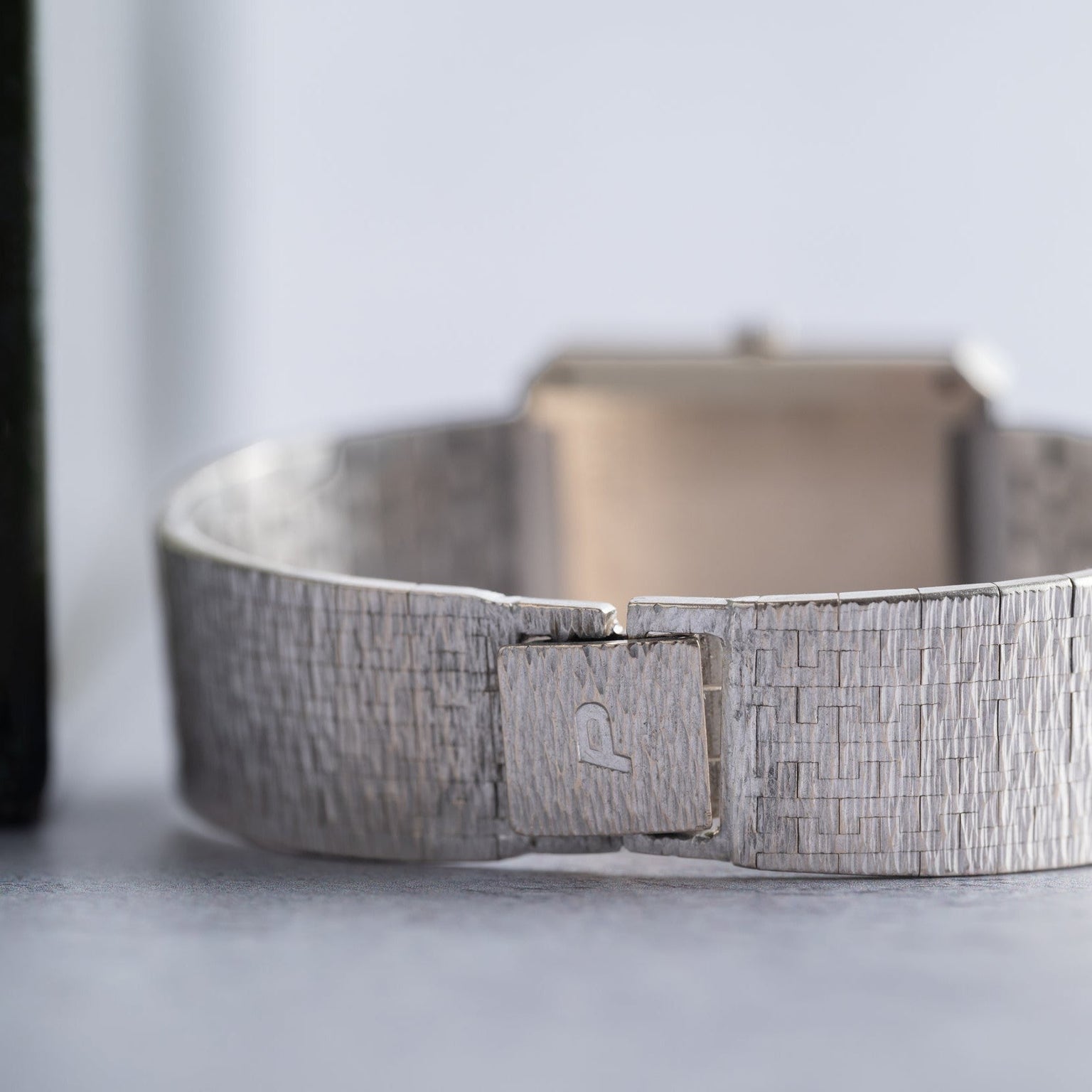 Close-up of a textured silver band on the Piaget Onyx Diamond Dress Watch, featuring a clasp engraved with the signature P logo.