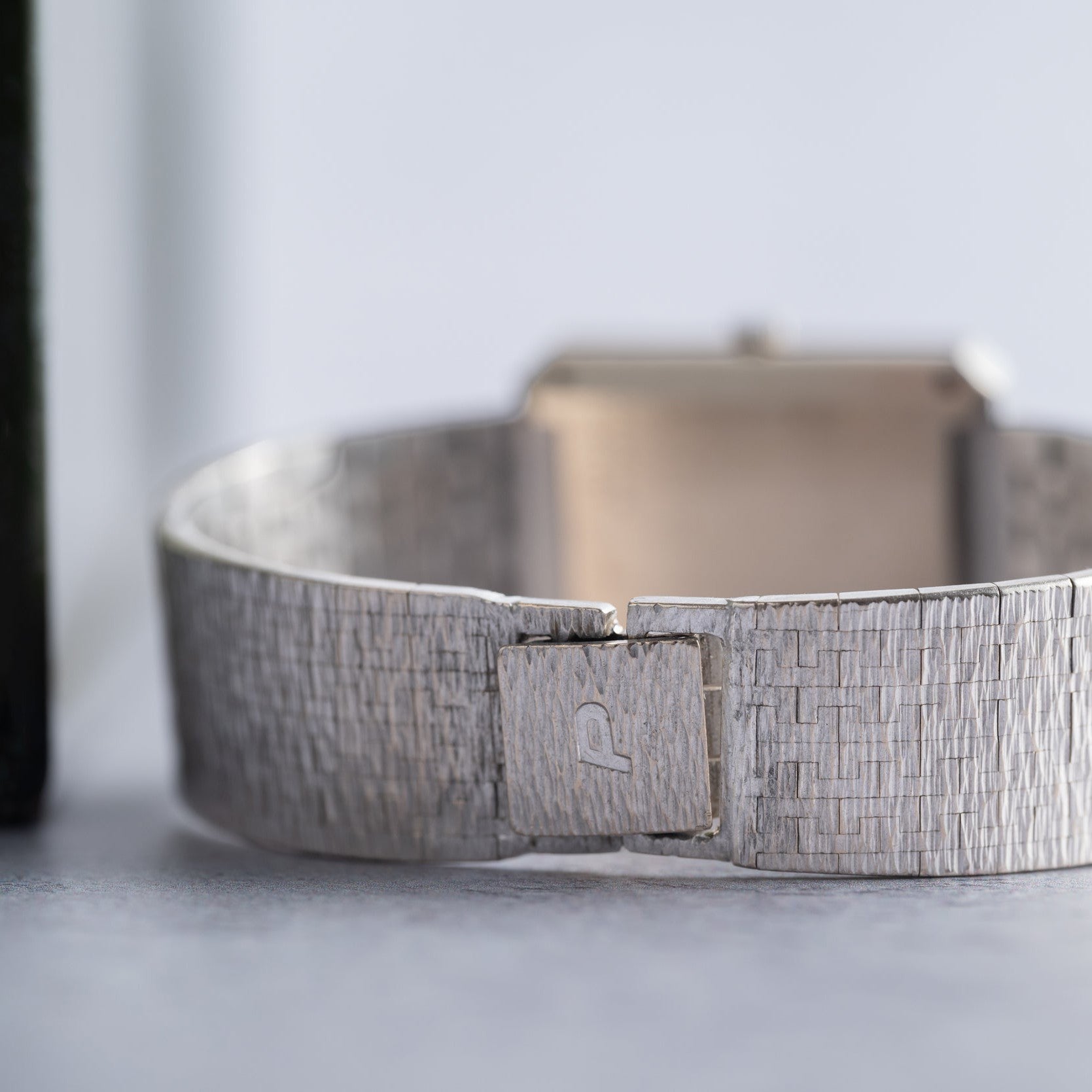 Close-up of a textured silver band on the Piaget Onyx Diamond Dress Watch, featuring a clasp engraved with the signature P logo.