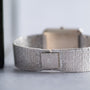 Close-up of a textured silver band on the Piaget Onyx Diamond Dress Watch, featuring a clasp engraved with the signature P logo.