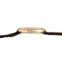 Side view of the Cartier Ellipse gold wristwatch featuring a round crown and a dark leather strap.