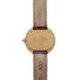 Back of the Cartier Ellipse wristwatch with gold case and brown leather strap, featuring engraved details.