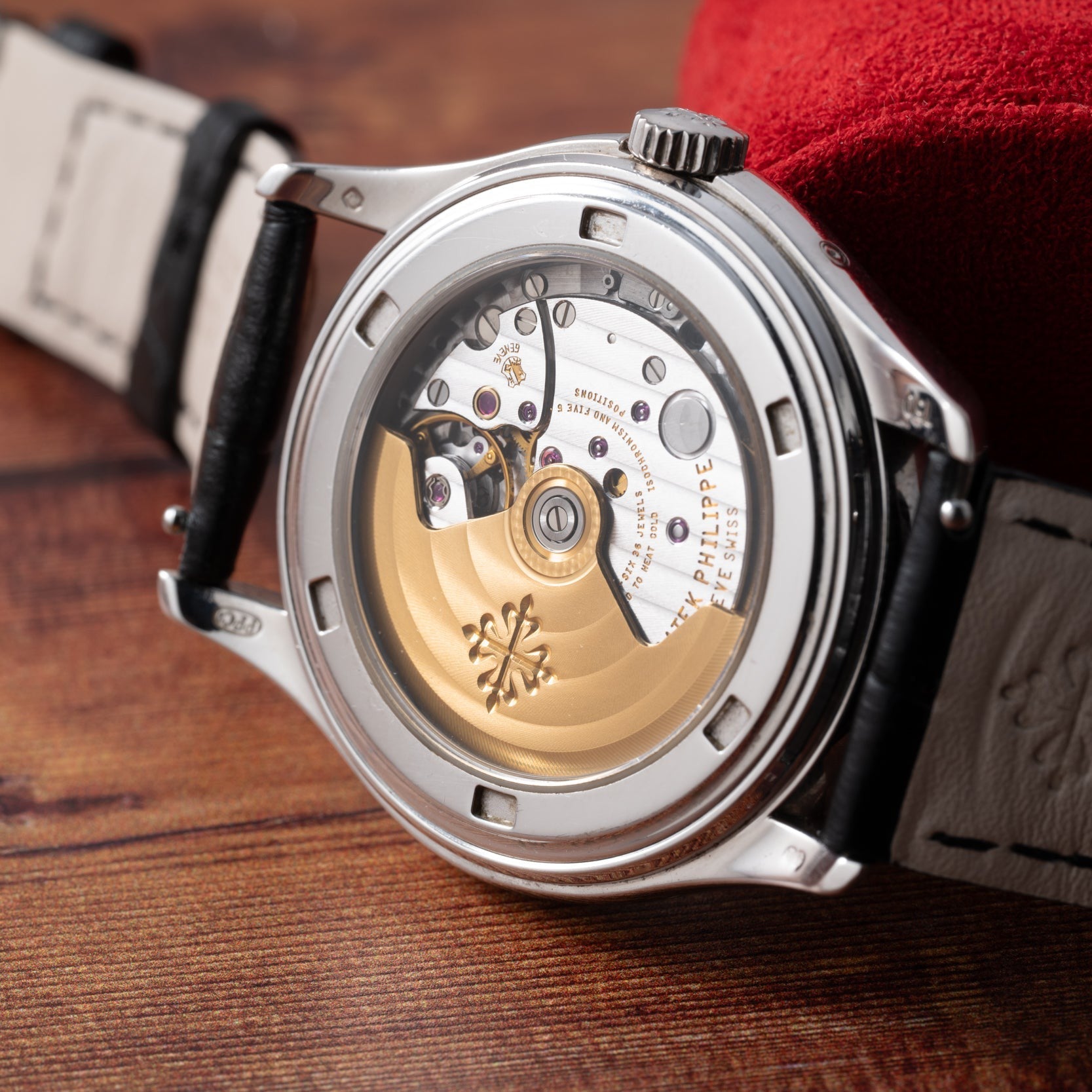 Close-up of the back of the Patek Philippe Annual Calendar Moonphase watch, revealing its exposed mechanical movement and gold rotor.