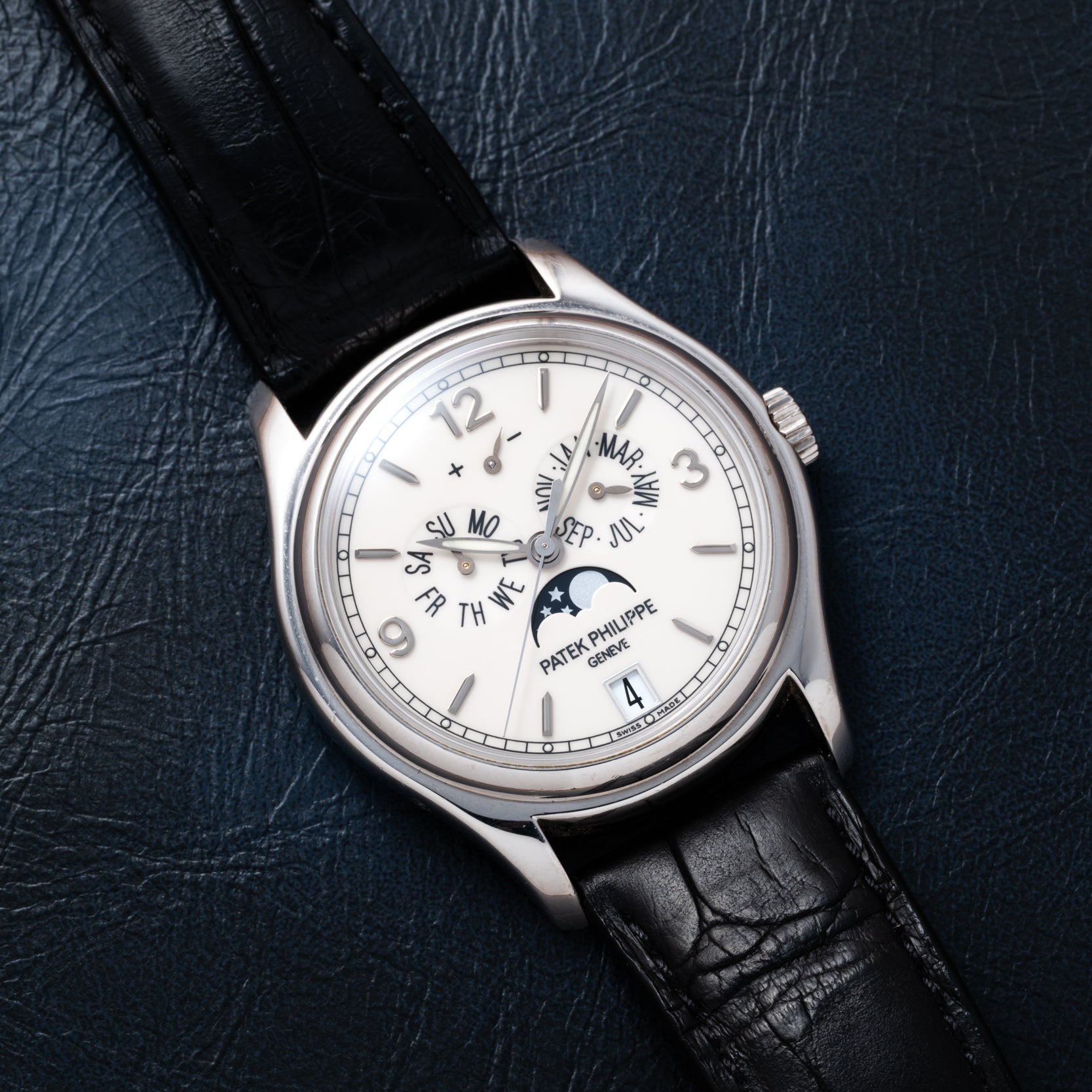 Patek Philippe Annual Calendar Moonphase wristwatch displayed on a dark leather surface.