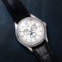 Patek Philippe Annual Calendar Moonphase wristwatch displayed on a dark leather surface.